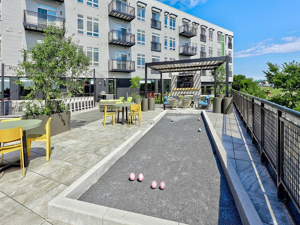 a pool with pink balls on it in front of an apartment building